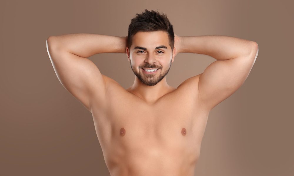 Young,Man,Showing,Hairless,Armpits,After,Epilation,Procedure,On,Brown